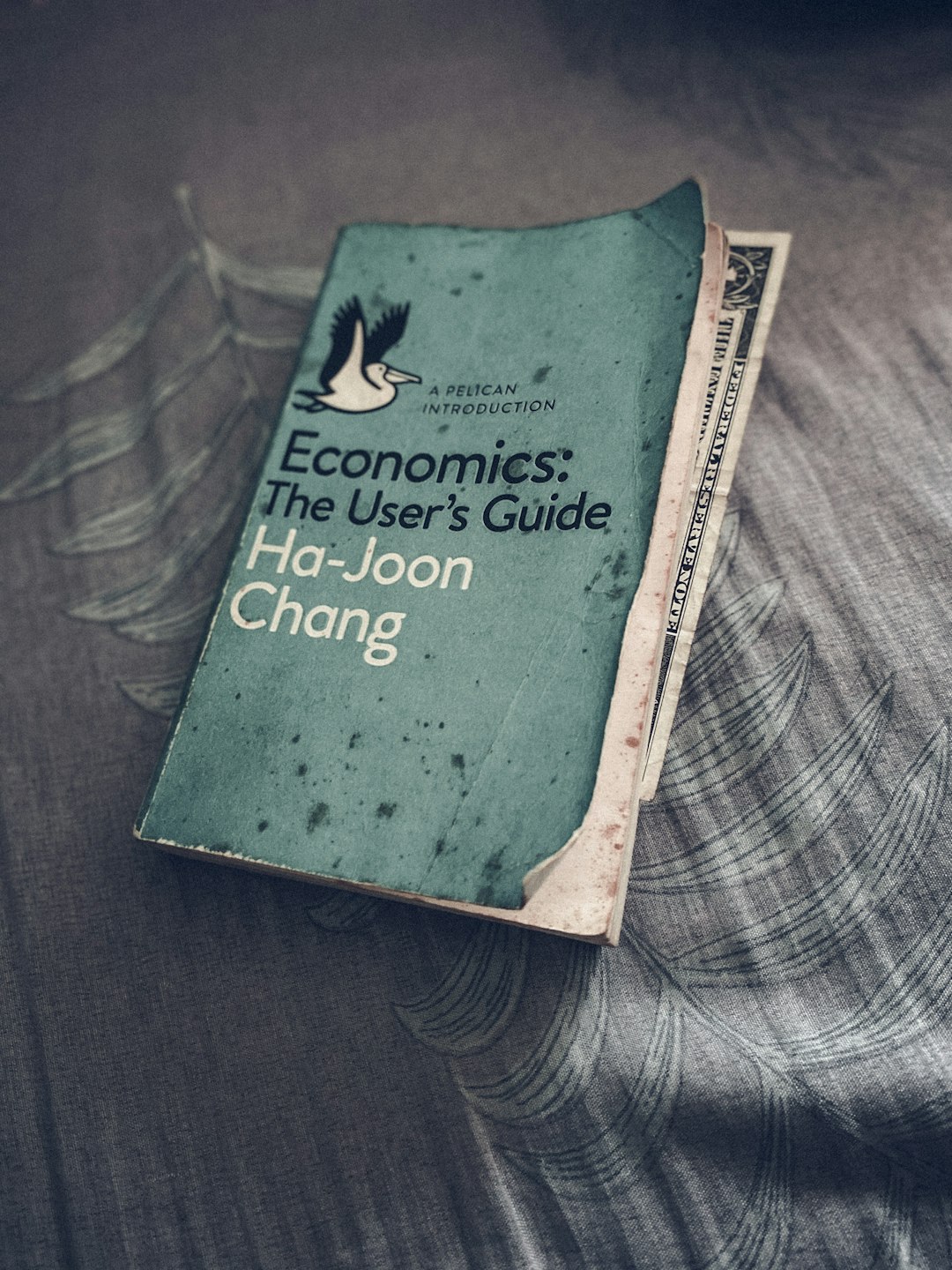 지정학적 위기 관련 책 표지가 놓여 있고 금리·환율·유가 변화가 주식 투자 전략에 미치는 영향을 상징함