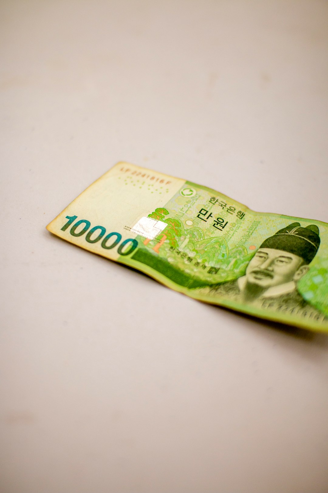 붉은 하락 화살표와 하염없이 떨어지는 원화 동전이 겹쳐 보이며, 환율 급등과 코스피 하락으로 인한 금융시장 불안과 국민연금 환헤지 논의를 상징함